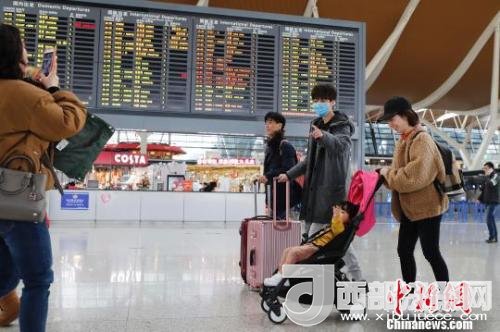 旅客帶著孩子前往辦票柜臺辦理登機(jī)手續(xù)?！∫罅⑶?攝