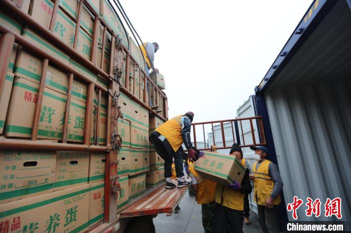 圖為鐵路裝卸作業(yè)人員正在將云南特色農產品裝入集裝箱?！詈?攝