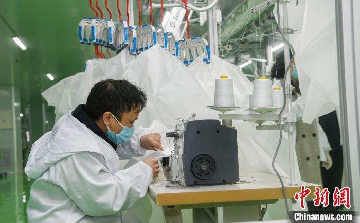 工人生產(chǎn)防護服，保障抗疫物資供應(yīng)。廣安市委宣傳部供圖