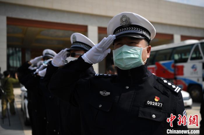 圖為交警們向醫(yī)療隊(duì)敬禮?！】灯?攝