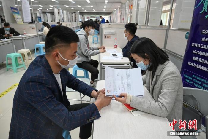 4月14日，招聘者在查看求職者簡歷。<a target='_blank'  data-cke-saved- >中新社</a>記者 王剛 攝