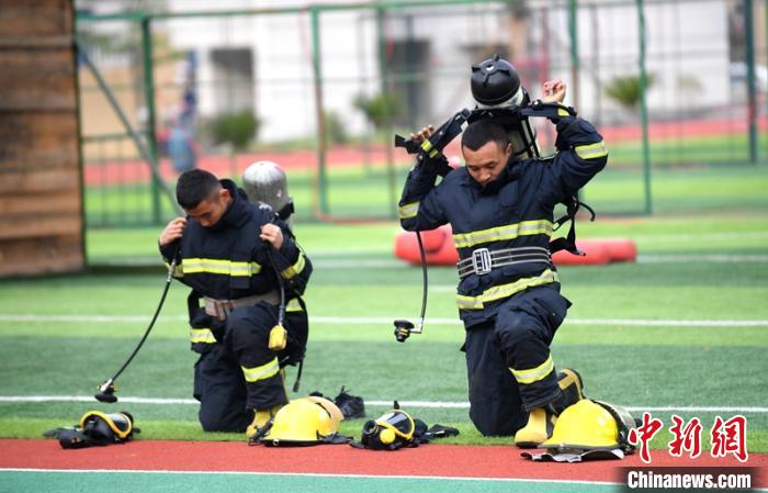 新消防員進(jìn)行穿戴空呼器展示?！⒅铱?攝