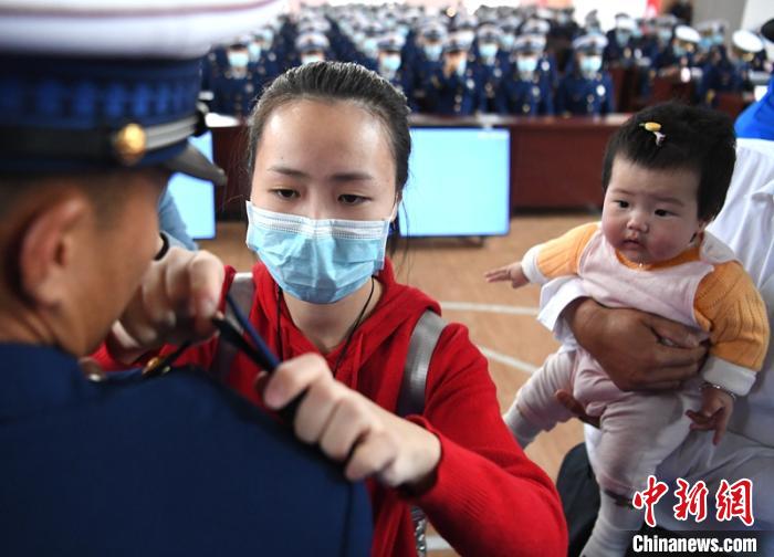 新消防員楊振的妻子彭莉與女兒現(xiàn)場見證丈夫加入“火焰藍(lán)”的神圣時刻。　劉忠俊 攝