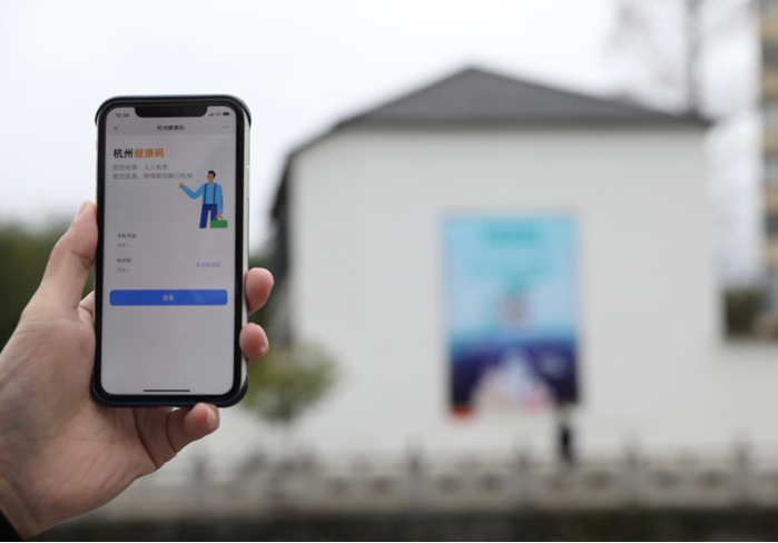 在浙江省杭州市臨安區(qū)天目山鎮(zhèn)，一名居民在“杭州健康碼”海報(bào)上掃碼申領(lǐng)個(gè)人二維碼。新華社發(fā)