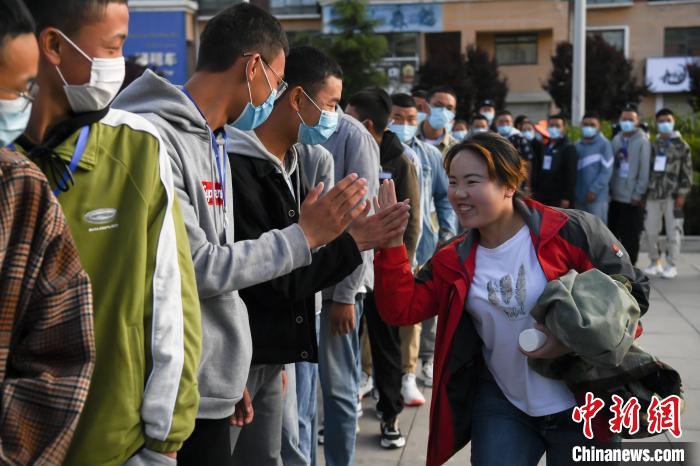 7月7日，拉薩三高考點外，領(lǐng)隊老師與考生擊掌鼓勁加油。　何蓬磊 攝