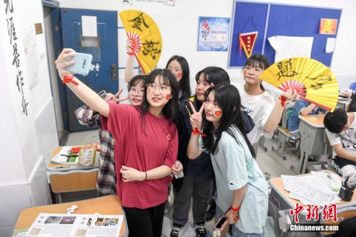 資料圖：6月6日，2021年高考前夕，湖南長(zhǎng)沙同升湖實(shí)驗(yàn)學(xué)校高三年級(jí)，考生們?cè)诮淌覂?nèi)合影。 楊華峰 攝