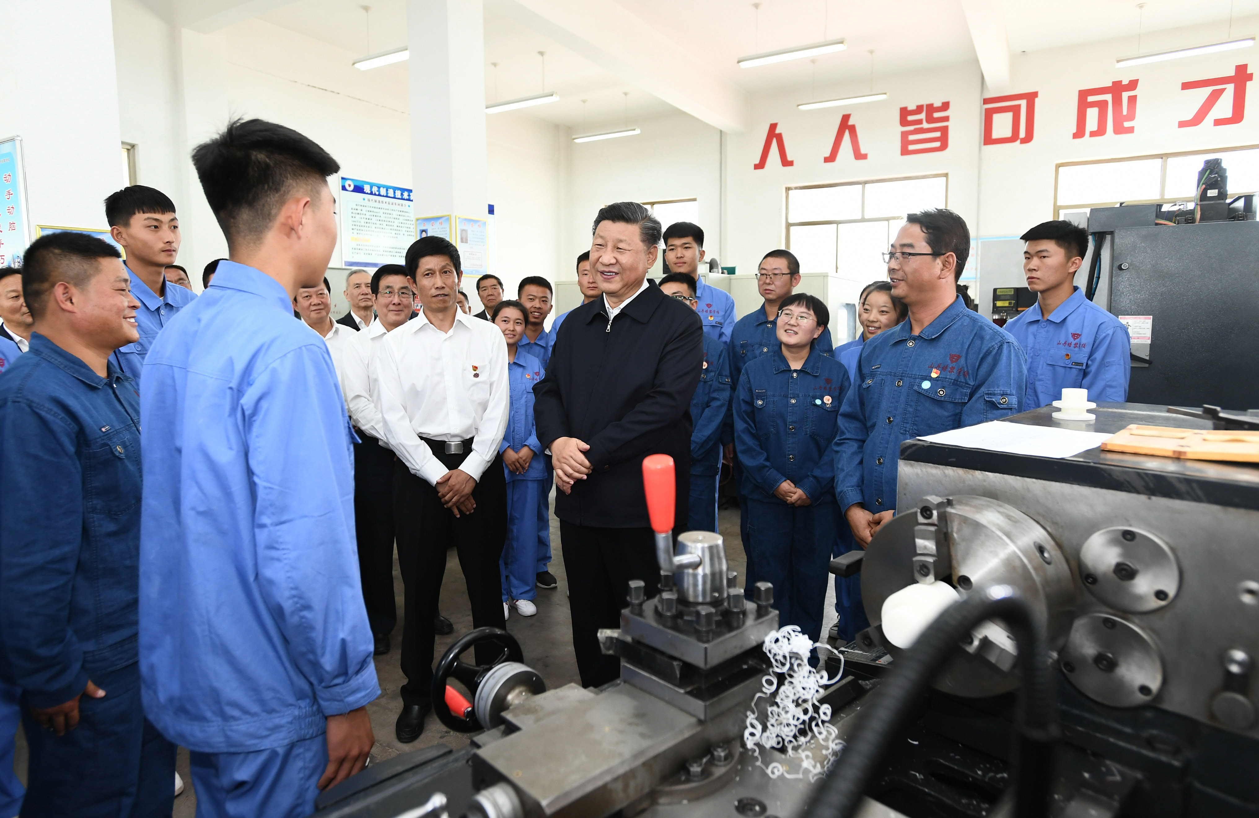 2019年8月20日，習(xí)近平在甘肅省張掖市山丹培黎學(xué)校現(xiàn)代制造技術(shù)實(shí)訓(xùn)室，觀看職業(yè)技能實(shí)訓(xùn)，同師生親切交流。