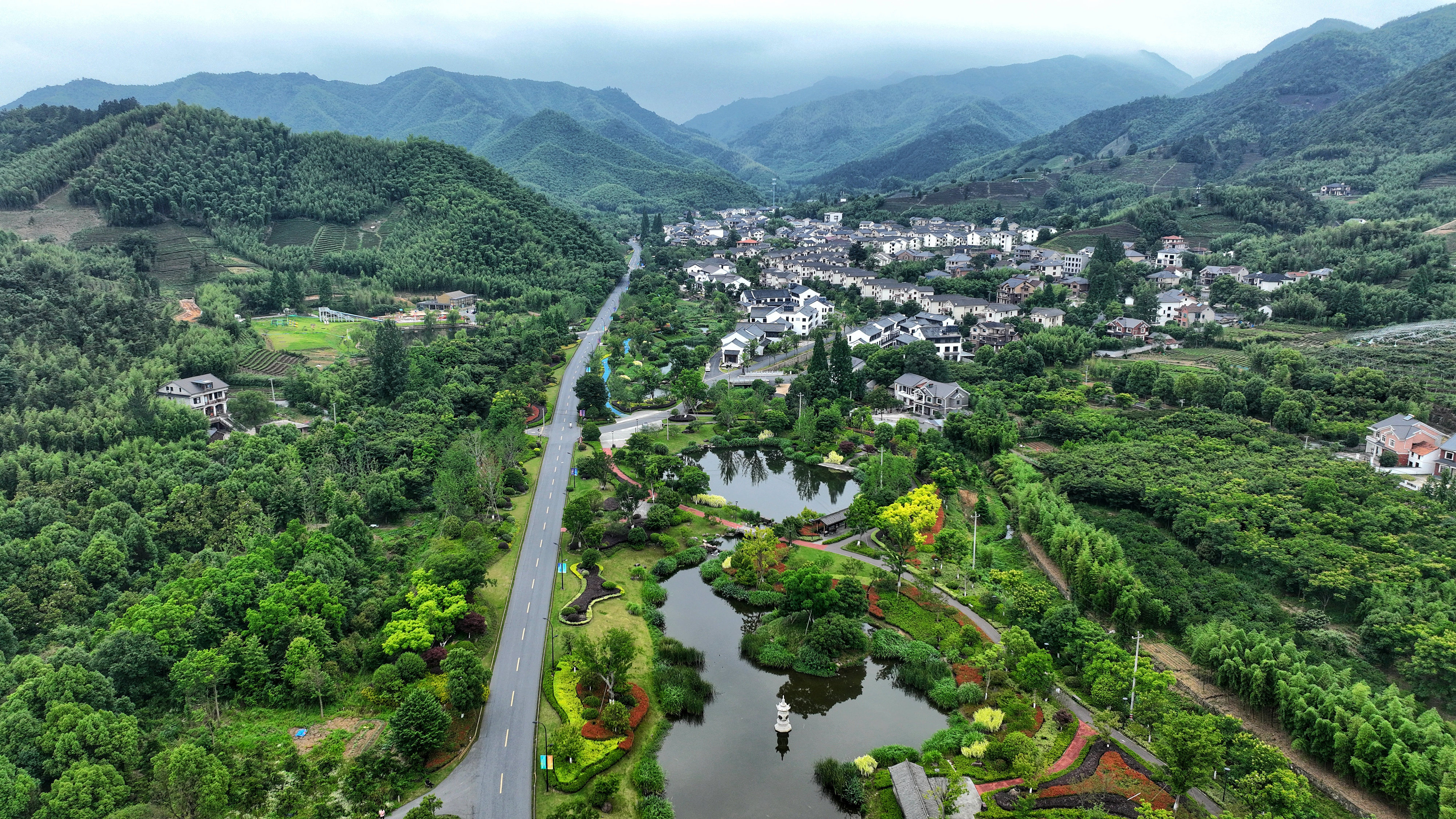 2023年6月6日，杭州余杭區(qū)徑山鎮(zhèn)鄉(xiāng)村，生態(tài)碧水、沿路花海與村莊農(nóng)房相映成趣，構(gòu)成一幅美麗的山水田園畫。