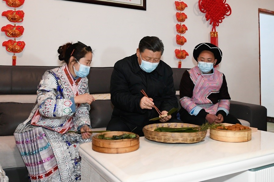 2021年2月3日下午，習(xí)近平在貴州畢節(jié)市黔西縣新仁苗族鄉(xiāng)化屋村苗族村民趙玉學(xué)家，同一家人邊聊家常邊制作當(dāng)?shù)貍鹘y(tǒng)節(jié)日食品黃粑。新華社記者 李學(xué)仁 攝