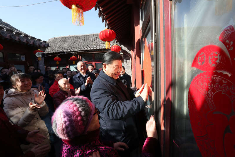 2019年2月1日上午，習(xí)近平在北京前門東區(qū)草廠四條胡同32號院，高興地拿起一幅“?！弊郑H自貼到門上，給這里的老街坊們拜年。新華社記者 鞠鵬 攝